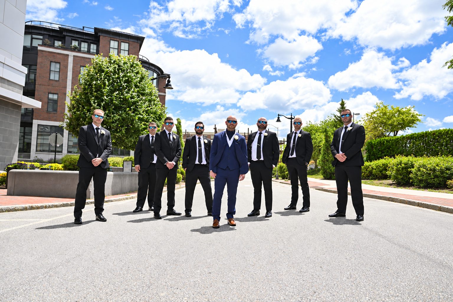 Groomsmen standing in a row on a city street