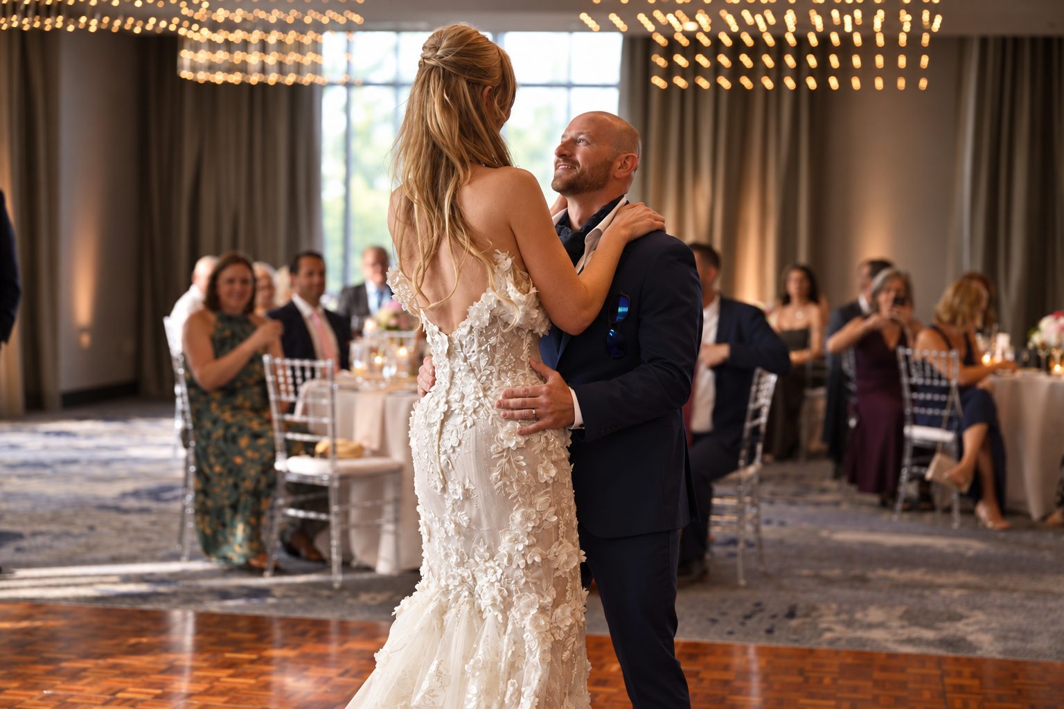 Bride and groom's first dance beneath string lights at their reception