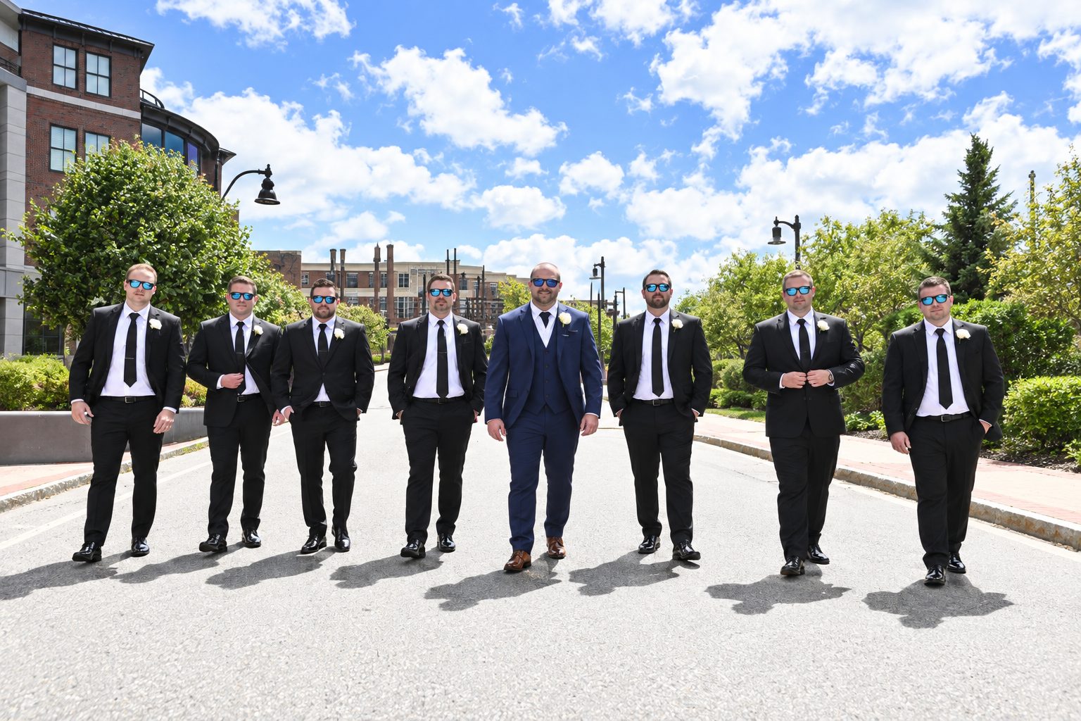Groomsmen in sunglasses walking down a city street